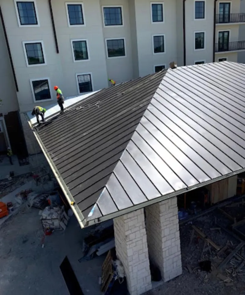 Crew installing standing seam metal roof panels on a commercial project in Capitola